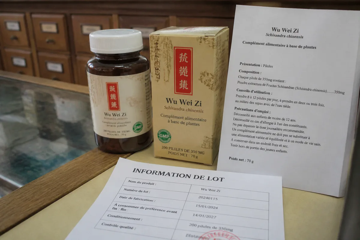 Boîte de complément de pharmacopée chinoise posée près d’une fiche d’étiquetage en français